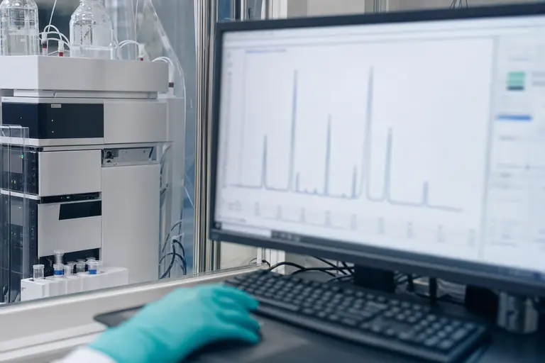 Laboratoriumscherm met een chromatogram naast analyseapparatuur